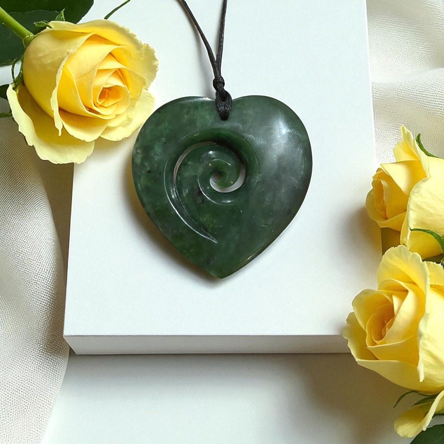 Greenstone heart-shaped pendant with koru design